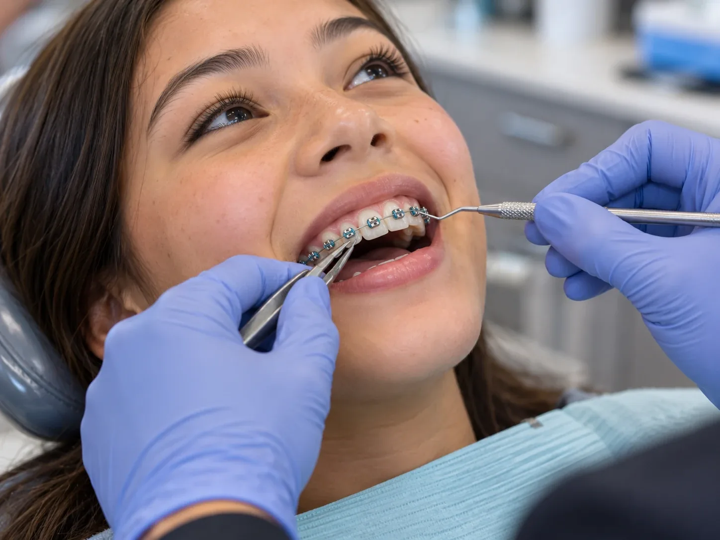 Clinician securing the first archwire into newly bonded metal braces.